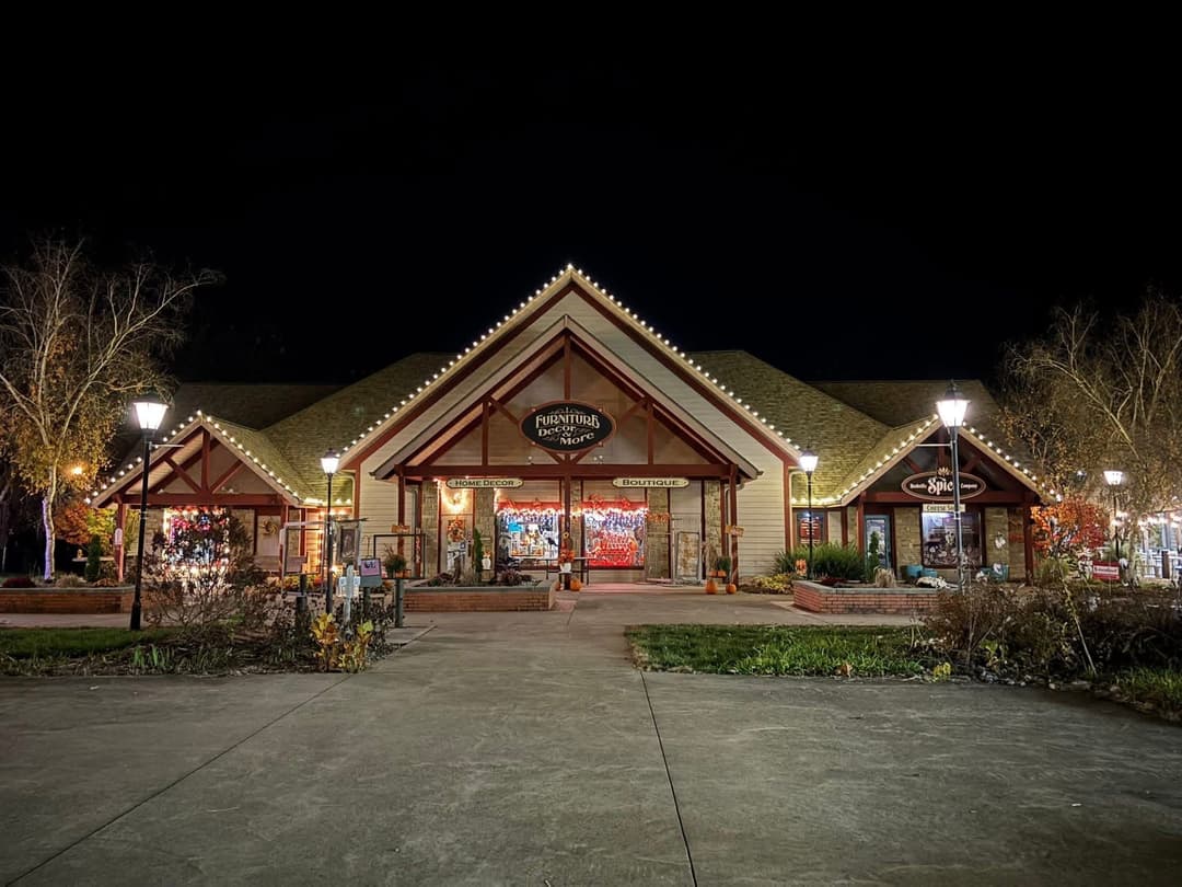 Cozy retail store exterior illuminated at night with festive lights and winter decor.